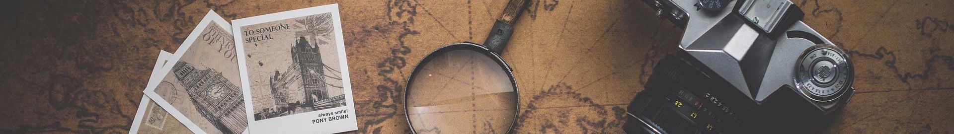 Genealogy stock header image showing postcards, a map, and magnifying glass