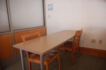 A small table with two chairs is an enclosed room.
