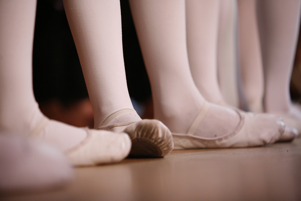 Five sets of feet wearing ballet shoes