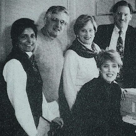 Five people look at the camera. A 1990s CRT monitor is just off-screen..