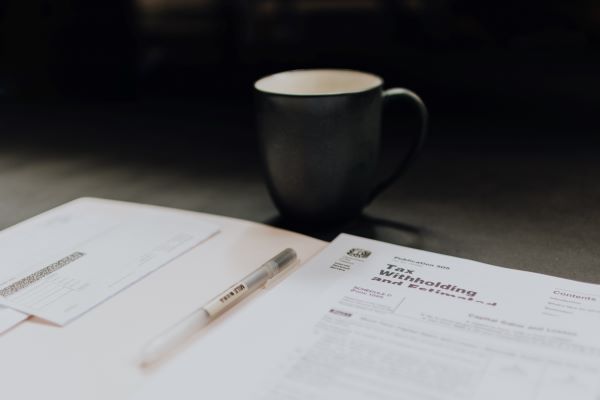 An image of a tax document with a black mug  in the background of probably coffee.