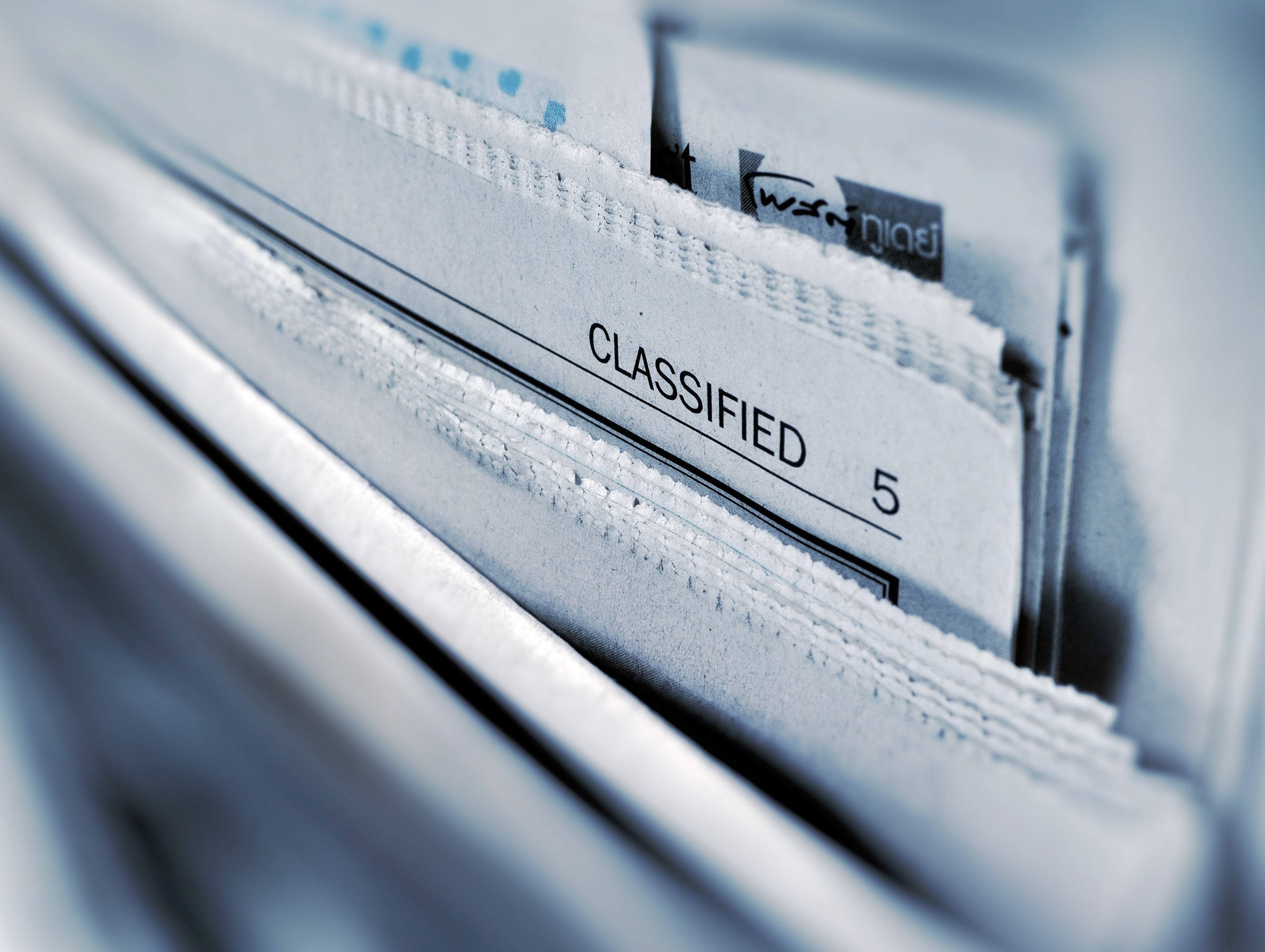 a group of paper files, one of which says "classified"