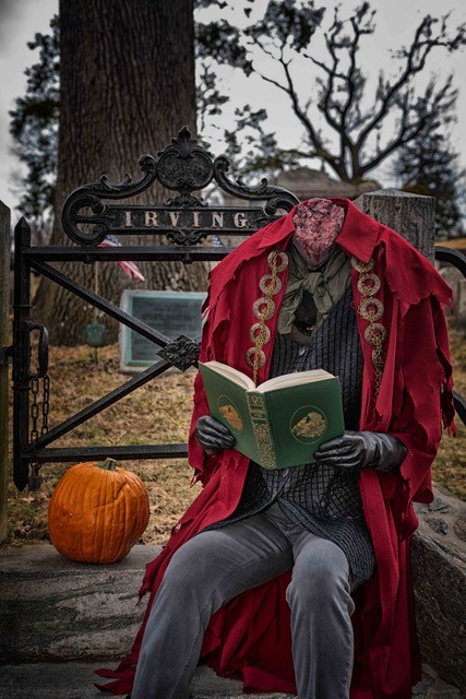 halloween theme: a headless gentleman sitting next to a pumpkin
