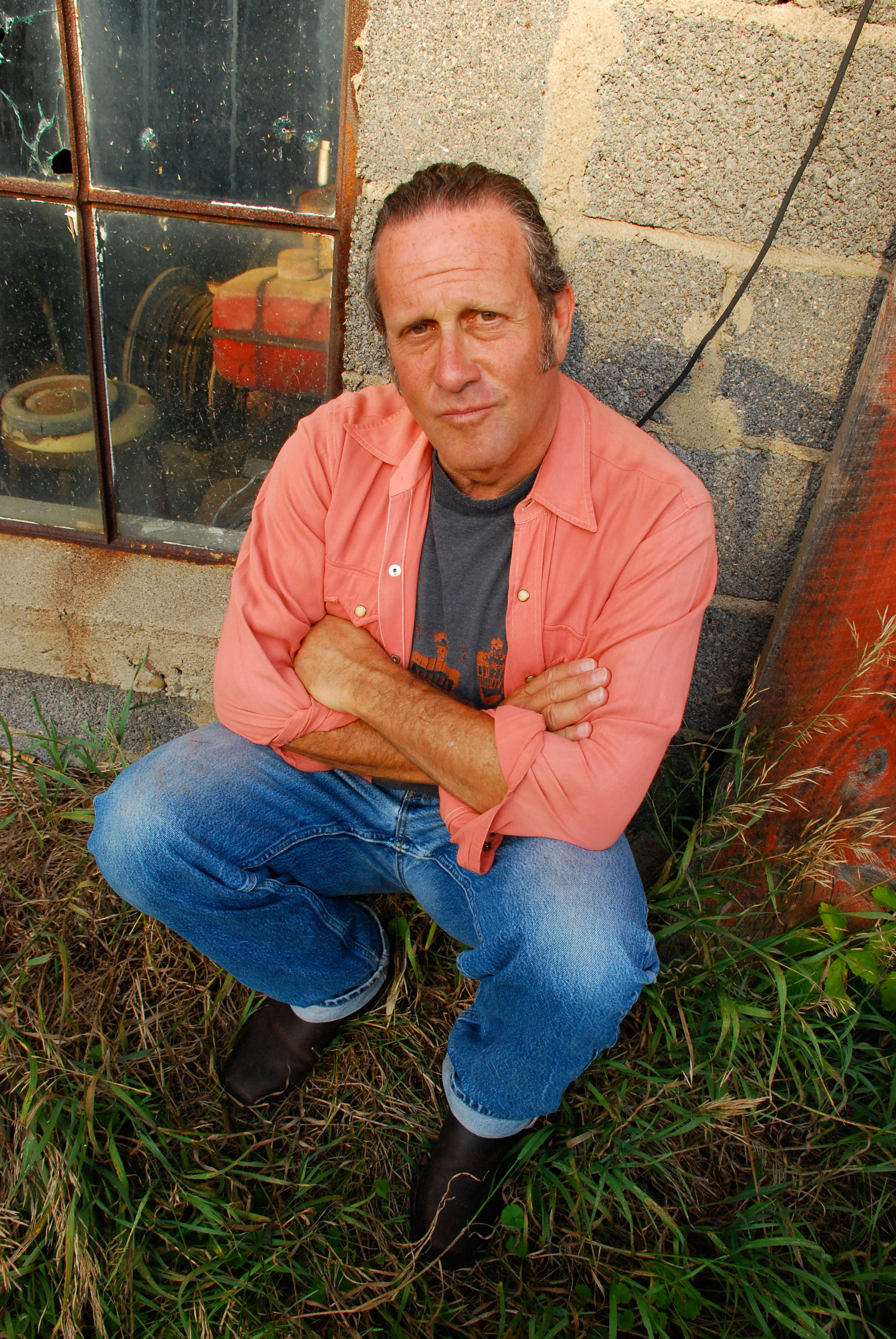 an image of the musician, Marc Berger, in denim and a coral button front shirt