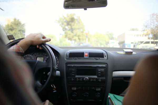 Interior of car, hand holding steering wheel