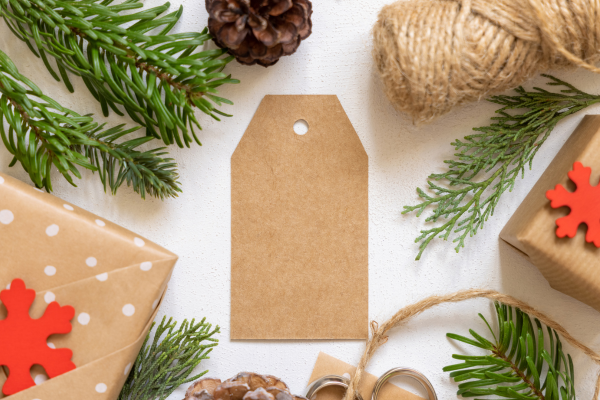 gift tag surrounded by gifts and holiday greenery