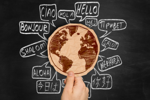 Hand holding globe surrounded by "Hello" in world languages 