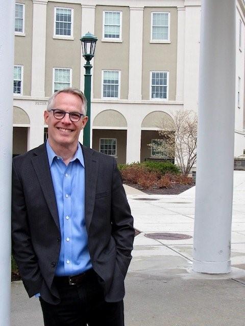 Photo of presenter, Curtis Butler, leaning against a wall